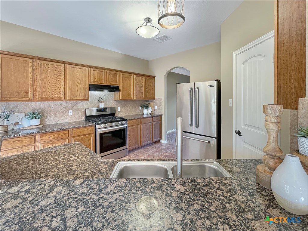 403 Red Hawk Drive Leander, TX 78641 - Photo 21 of 35 a kitchen with a refrigerator a stove top oven a sink and cabinets
