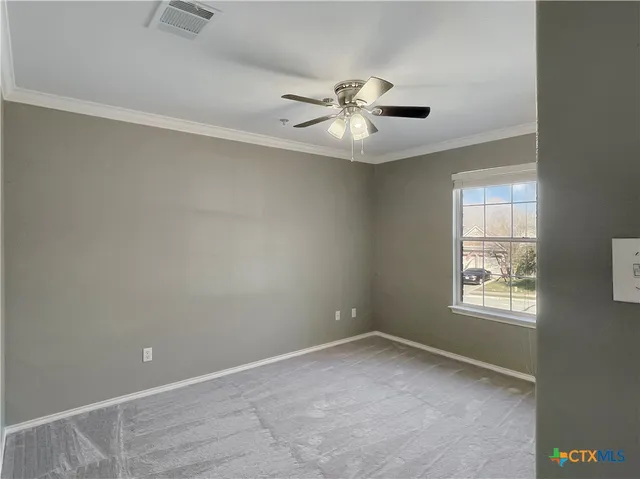 an empty room with windows and fan