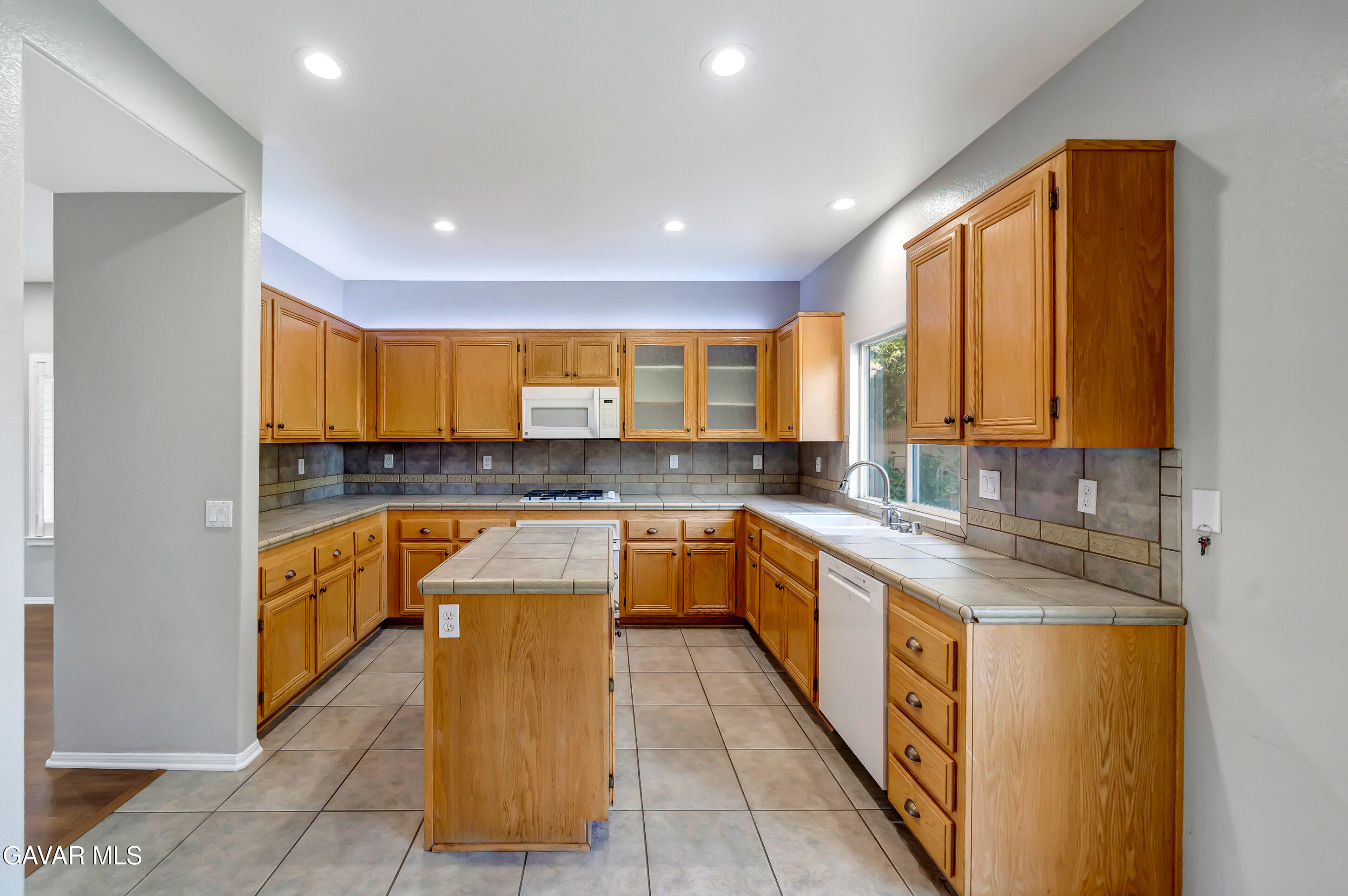 43826 Generation Avenue Lancaster, CA 93536 - Photo 22 of 61 a large kitchen with a large counter top a sink a window and stainless steel appliances