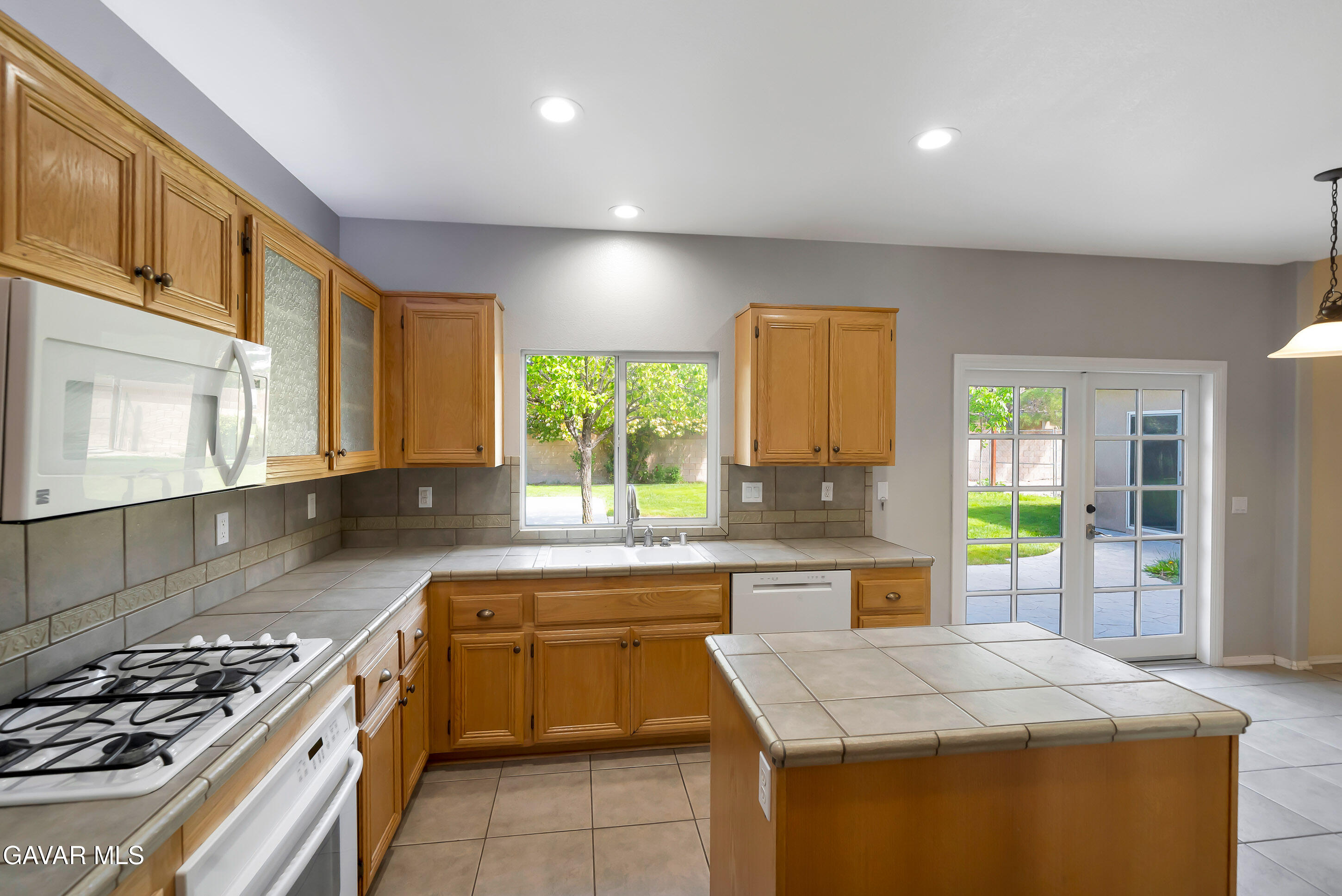 43826 Generation Avenue Lancaster, CA 93536 - Photo 26 of 61 a kitchen with a stove a sink a counter top space and cabinets
