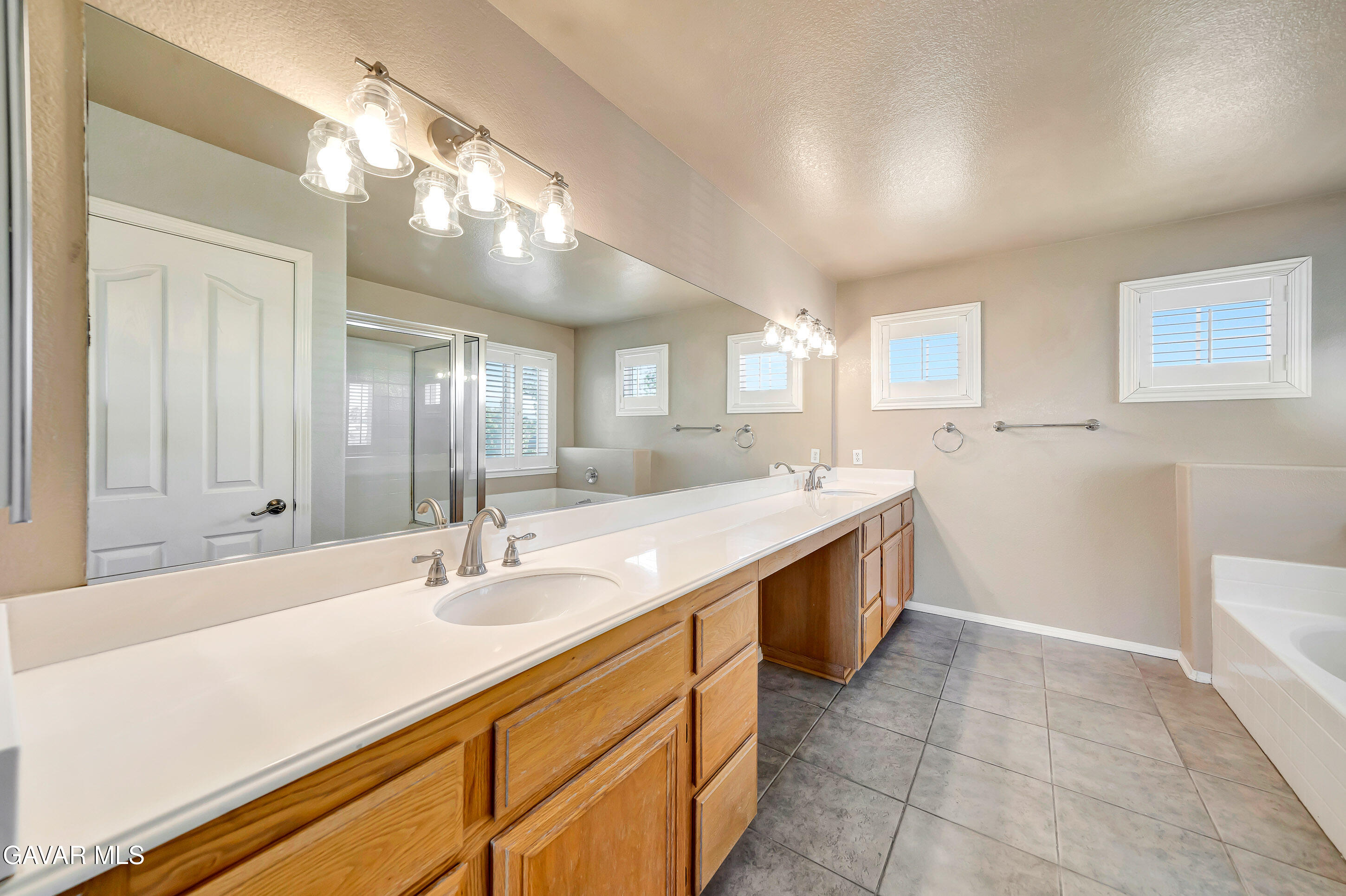43826 Generation Avenue Lancaster, CA 93536 - Photo 42 of 61 a spacious bathroom with a sink double vanity and a mirror