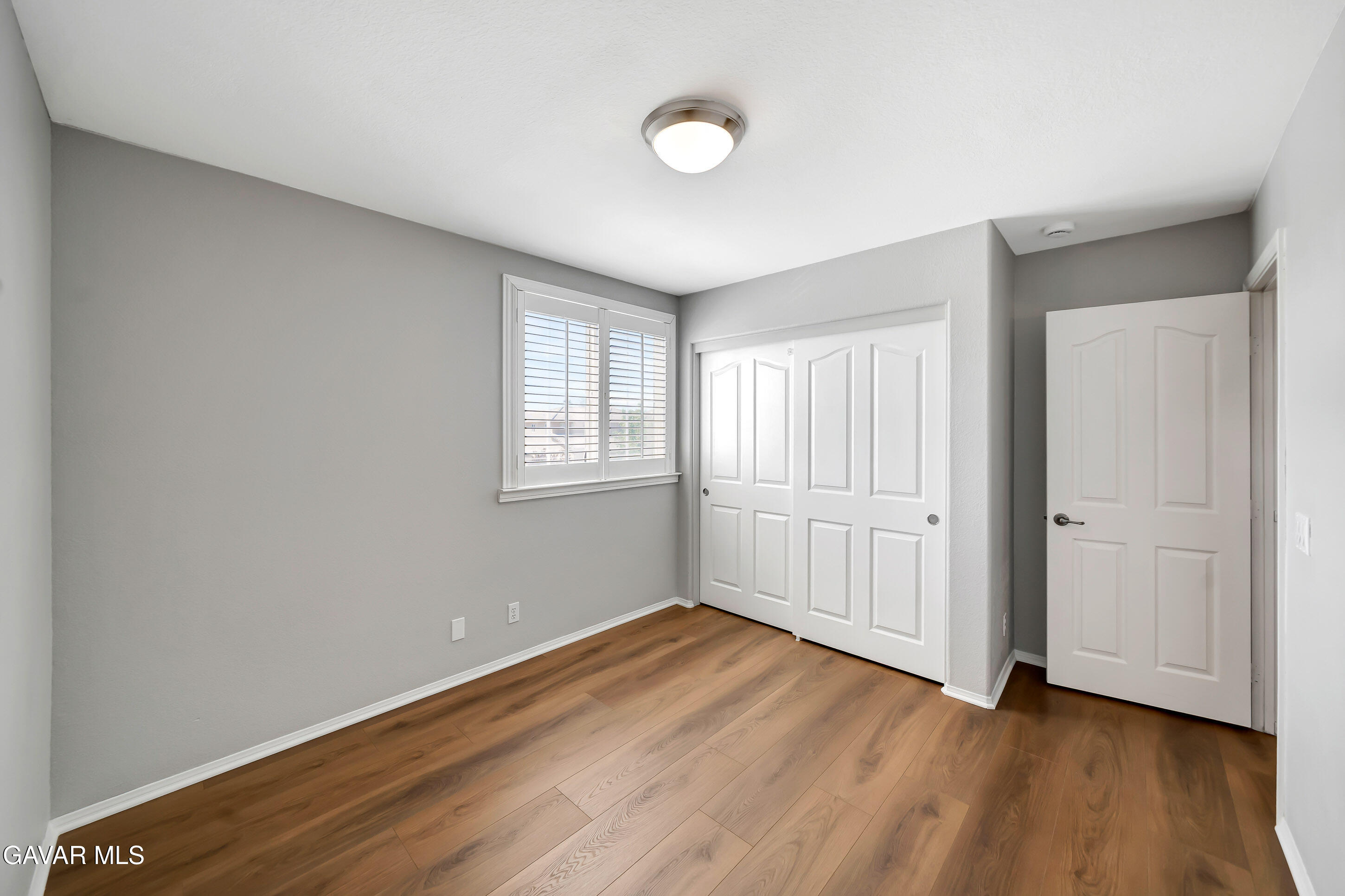 43826 Generation Avenue Lancaster, CA 93536 - Photo 49 of 61 an empty room with wooden floor and windows