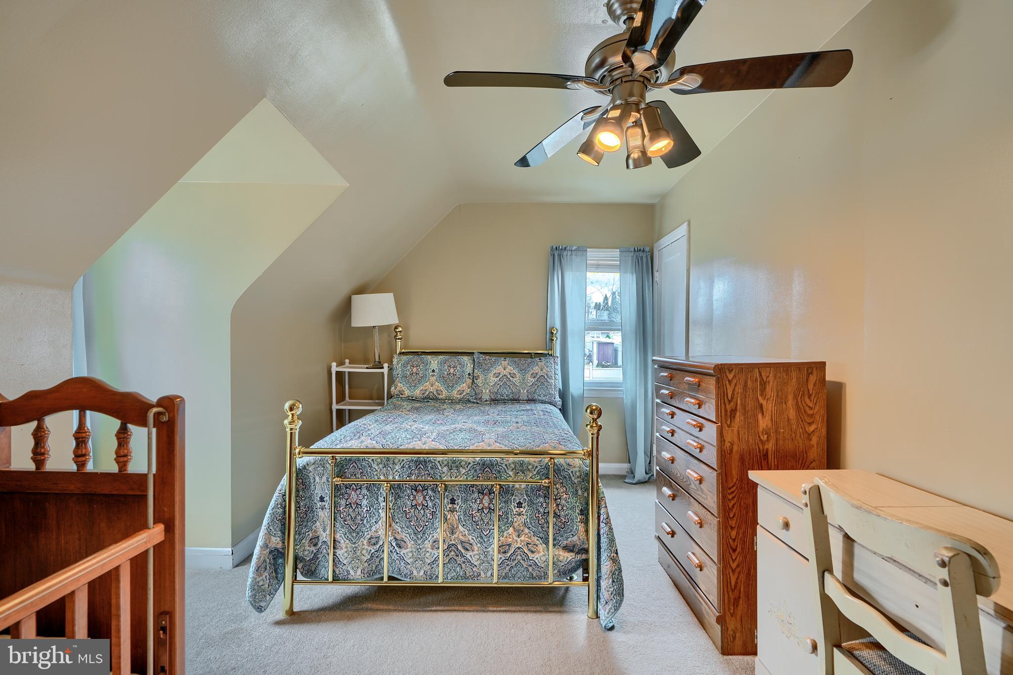 297 Hazel Avenue Baltimore, MD 21227 - Photo 27 of 56 a bedroom with a bed a mirror and lamp