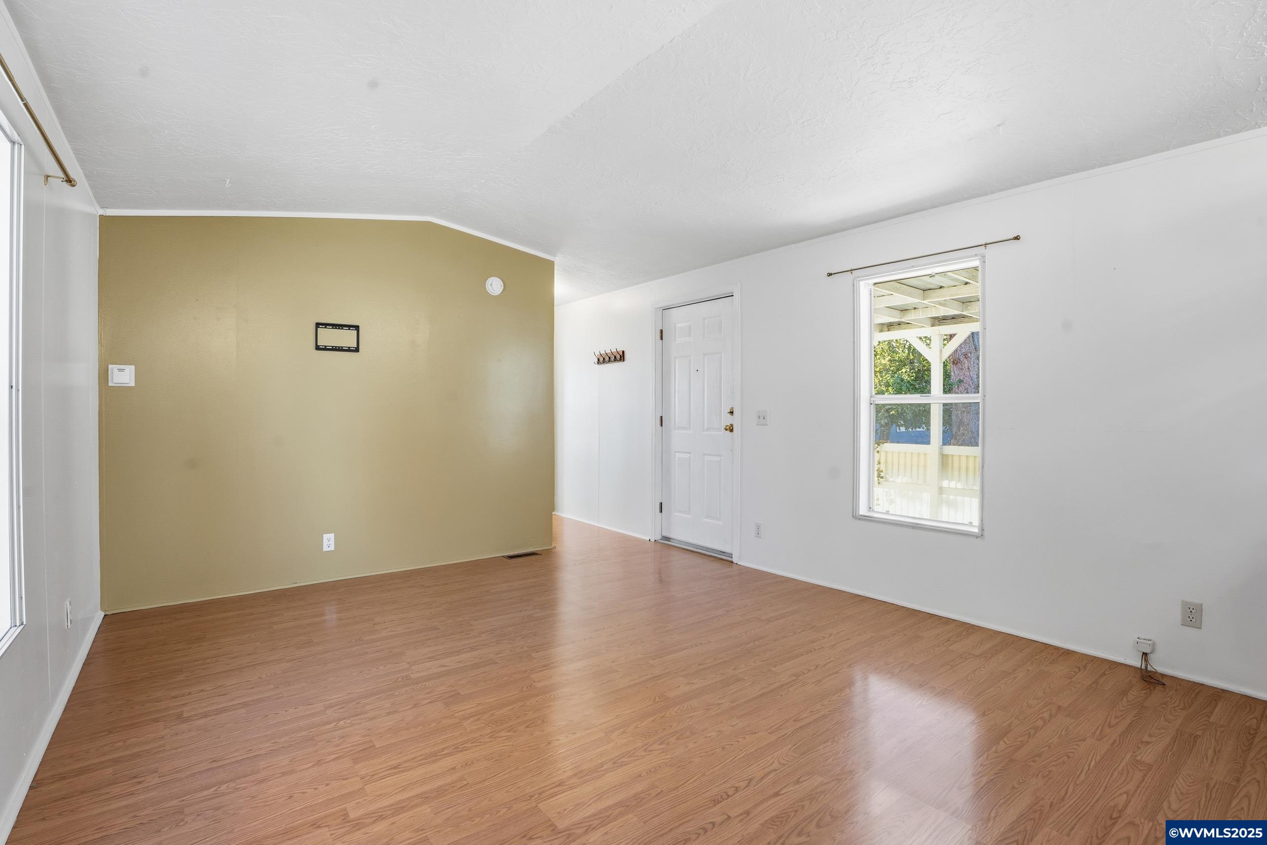 277 Edwards Road, Unit 145 Monmouth, OR 97361 - Photo 19 of 47 a view of an empty room with wooden floor and a window