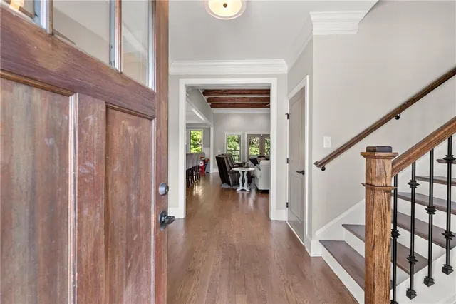 a view of a hallway with wooden floor and stairs