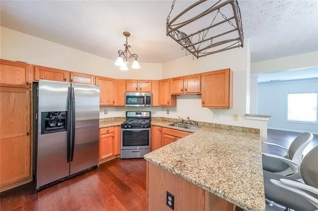 a kitchen with stainless steel appliances granite countertop a refrigerator a sink a stove and island