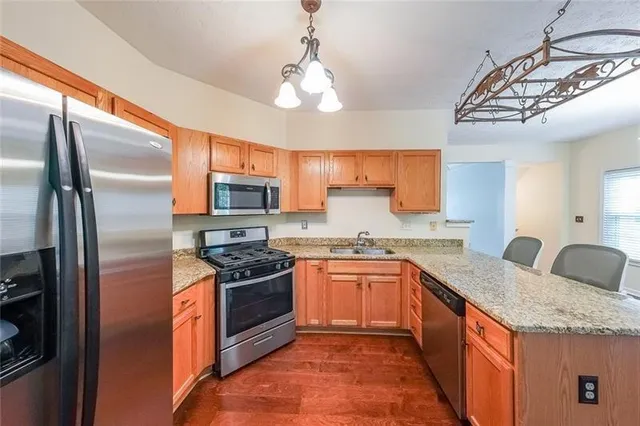 a kitchen with stainless steel appliances granite countertop a sink stove and refrigerator