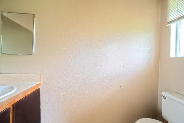 a bathroom with a sink a toilet and a window