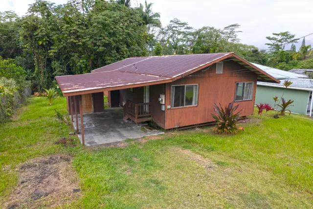 a backyard of a house with table and chairs