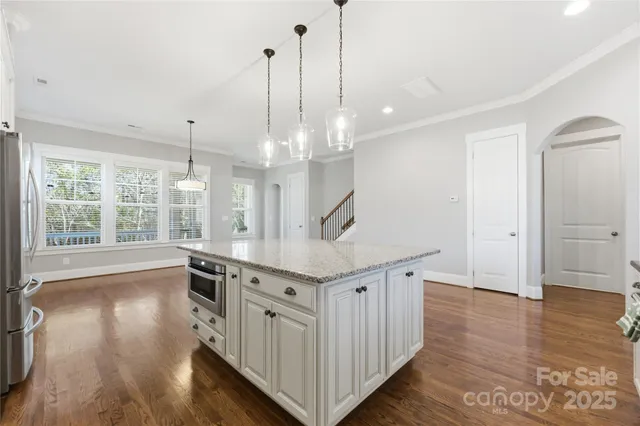 a kitchen with stainless steel appliances granite countertop a stove and a wooden floor