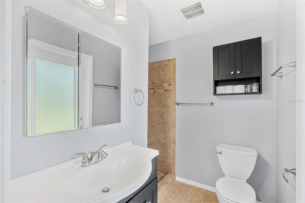 2923 Conway Gardens Road Orlando, FL 32806 - Photo 14 of 28 a bathroom with a toilet sink and mirror