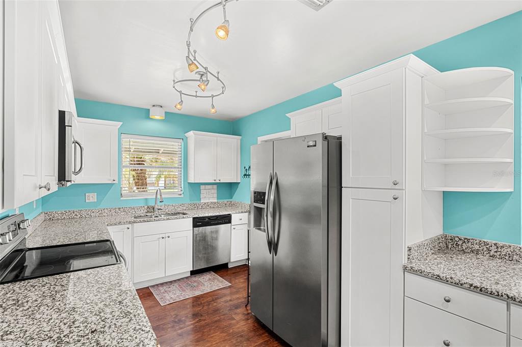 2923 Conway Gardens Road Orlando, FL 32806 - Photo 21 of 28 a kitchen with stainless steel appliances granite countertop a sink refrigerator and cabinets