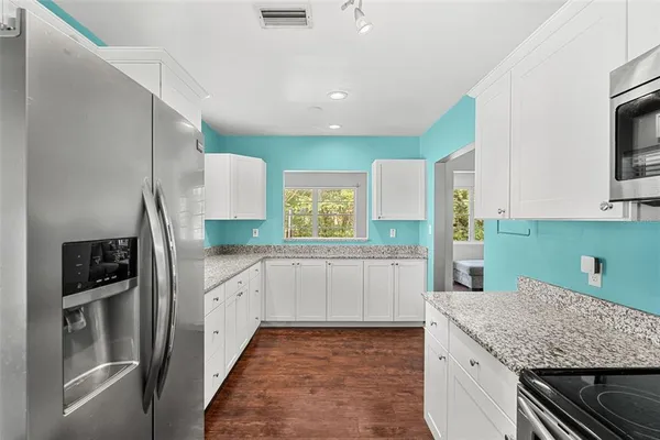 a kitchen with stainless steel appliances granite countertop a sink and a stove