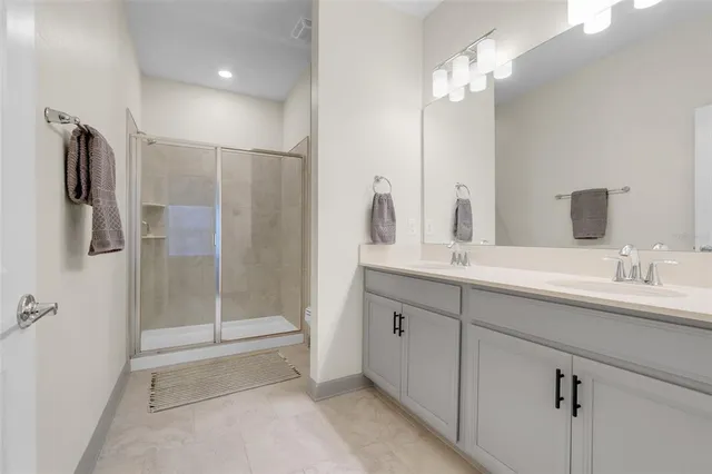 a bathroom with a double vanity sink mirror and shower