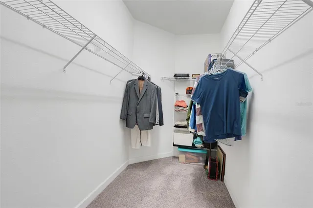 a view of walk in closet with clothes