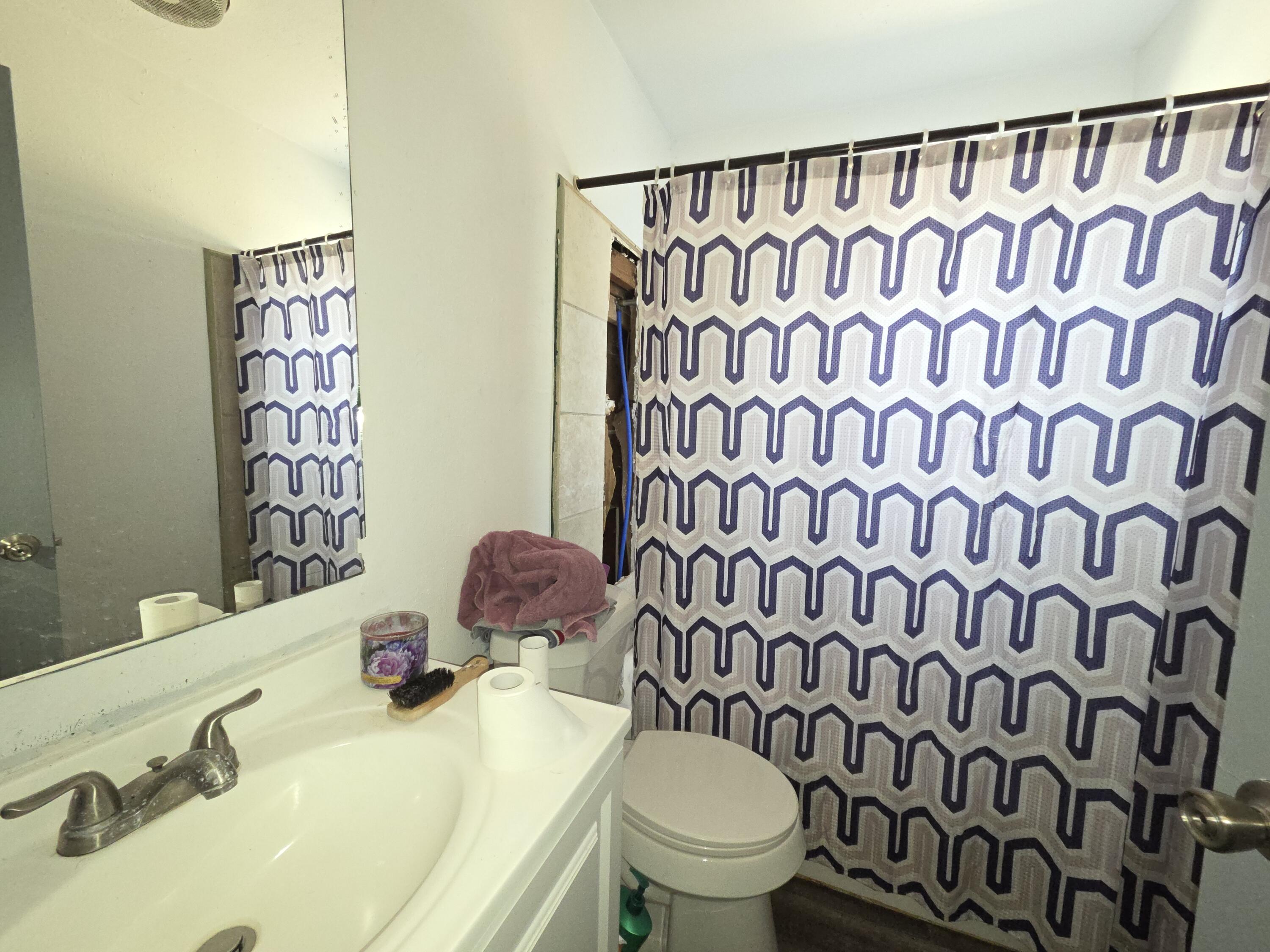 2401 East 10th Street Lubbock, TX 79403 - Photo 6 of 7 a bathroom with a sink and a mirror