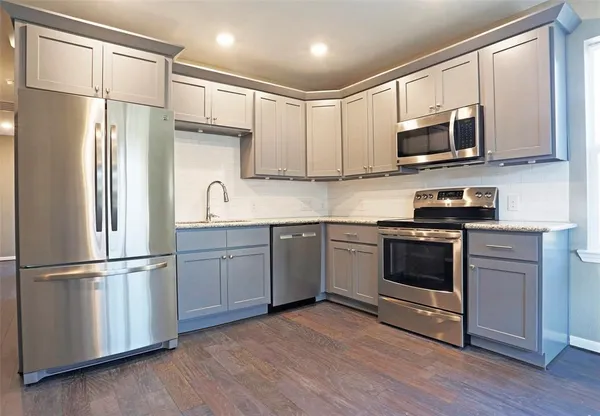 a kitchen with stainless steel appliances a refrigerator sink and microwave