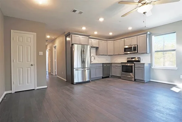 a kitchen with stainless steel appliances granite countertop a refrigerator and a stove top oven