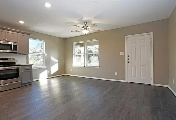 a view of an empty room with window and wooden floor