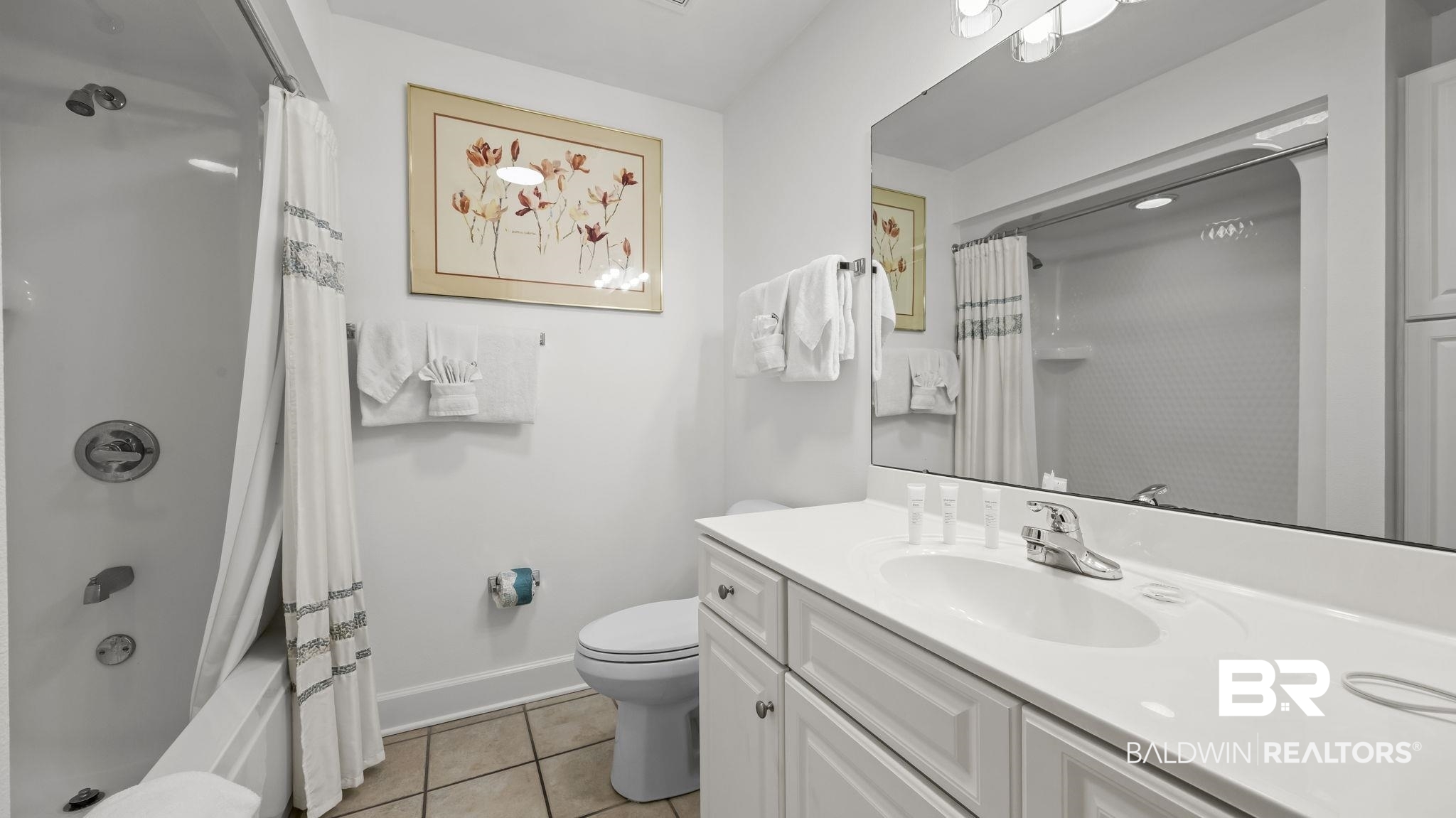 27580 Canal Road, Unit 1213 Orange Beach, AL 36561 - Photo 17 of 27 White vanity with an integrated sink, polished chrome faucet, and a large wall-mounted mirror