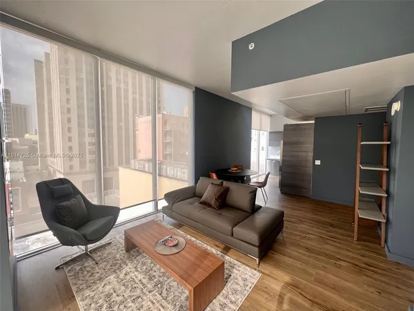 a living room with furniture and wooden floor