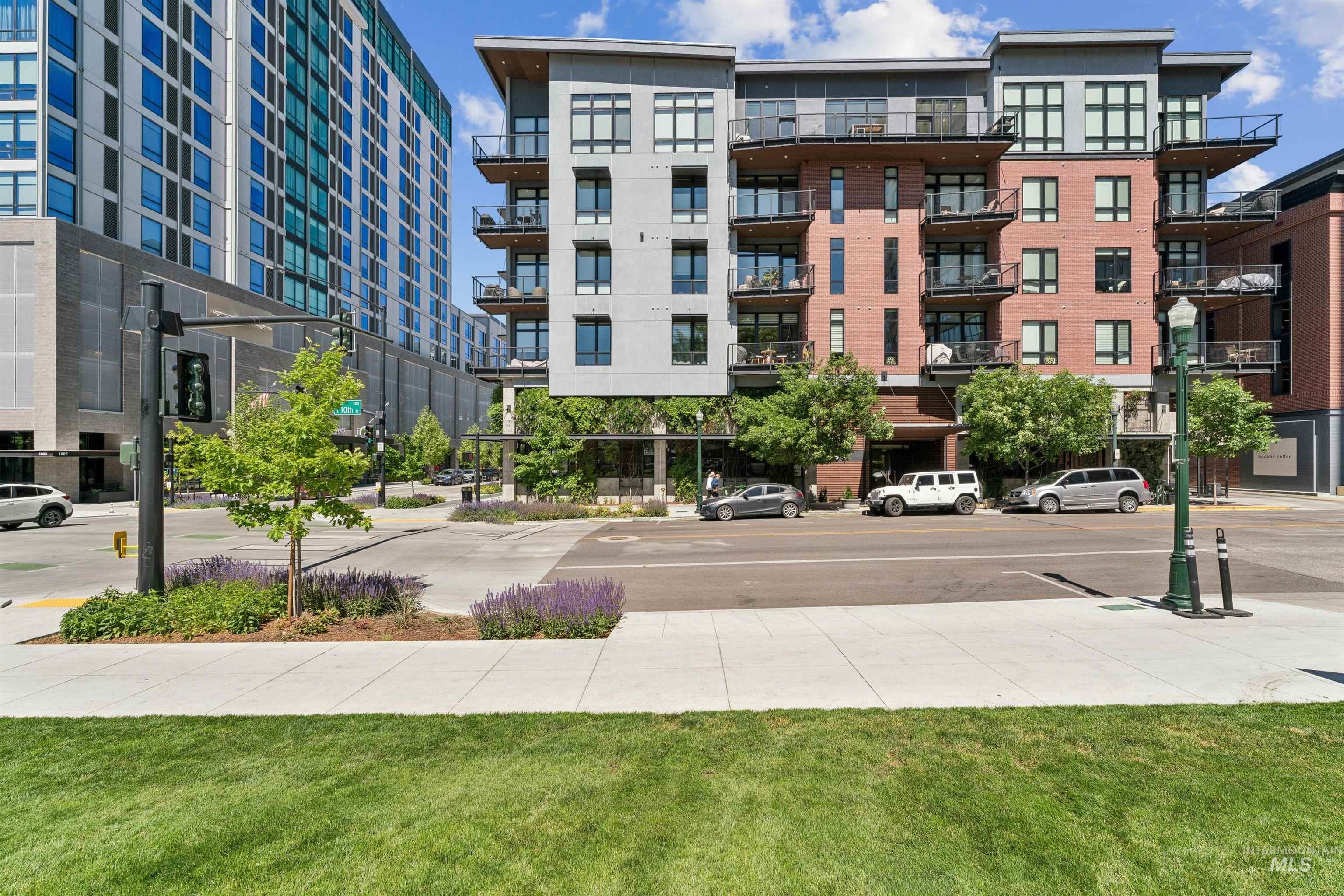 119 South 10th Street, Unit 307 Boise, ID 83702 - Photo 46 of 47 Modern multi-story building featuring a blend of brick and paneling, multiple balconies with glass railings, large windows, and street-level commercial spaces