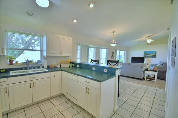 a kitchen with stainless steel appliances granite countertop a sink a stove a refrigerator and cabinets