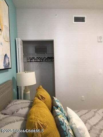 2760 Bosque Circle, Unit 307 Melbourne, FL 32940 - Photo 10 of 18 a bedroom with a bed and a mirror