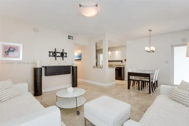a living room with furniture and a dining table with kitchen view