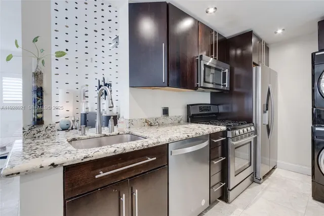 a kitchen with stainless steel appliances granite countertop a sink stove and refrigerator