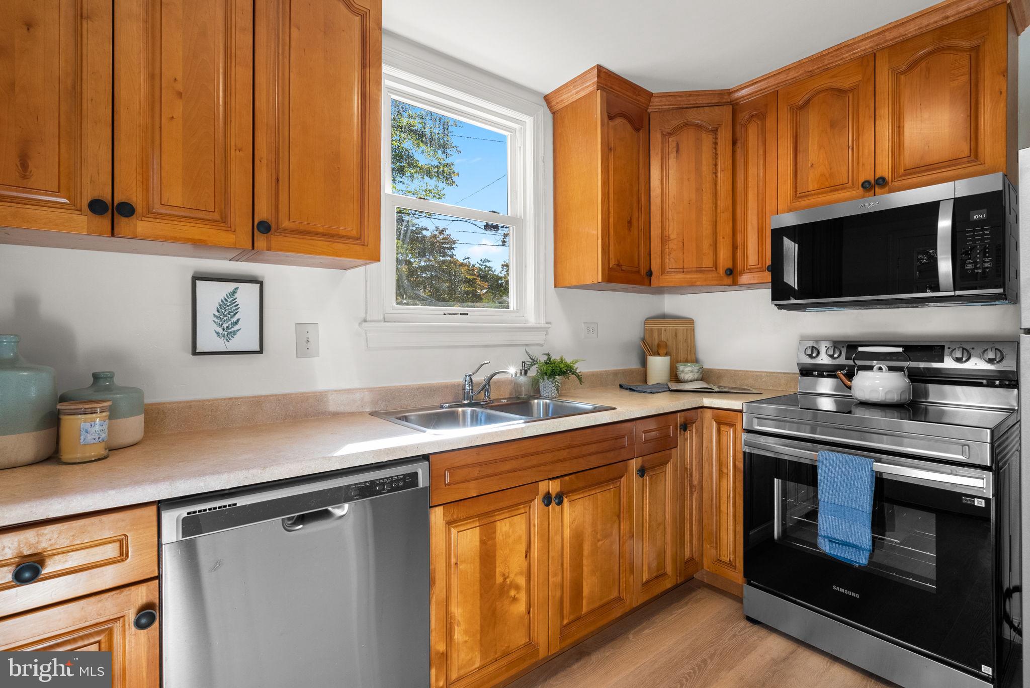 8702 Reading Road Silver Spring, MD 20901 - Photo 16 of 42 a kitchen with stainless steel appliances a stove a sink and a microwave