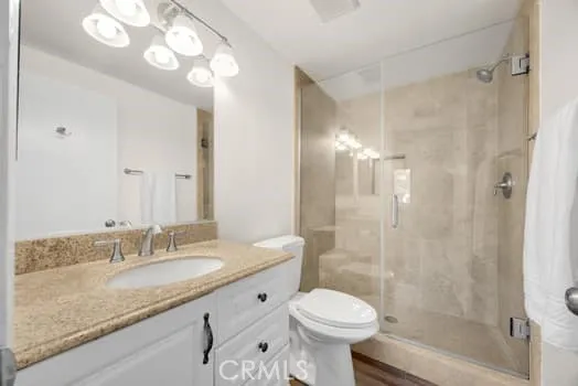 a bathroom with a granite countertop sink toilet a shower and a mirror