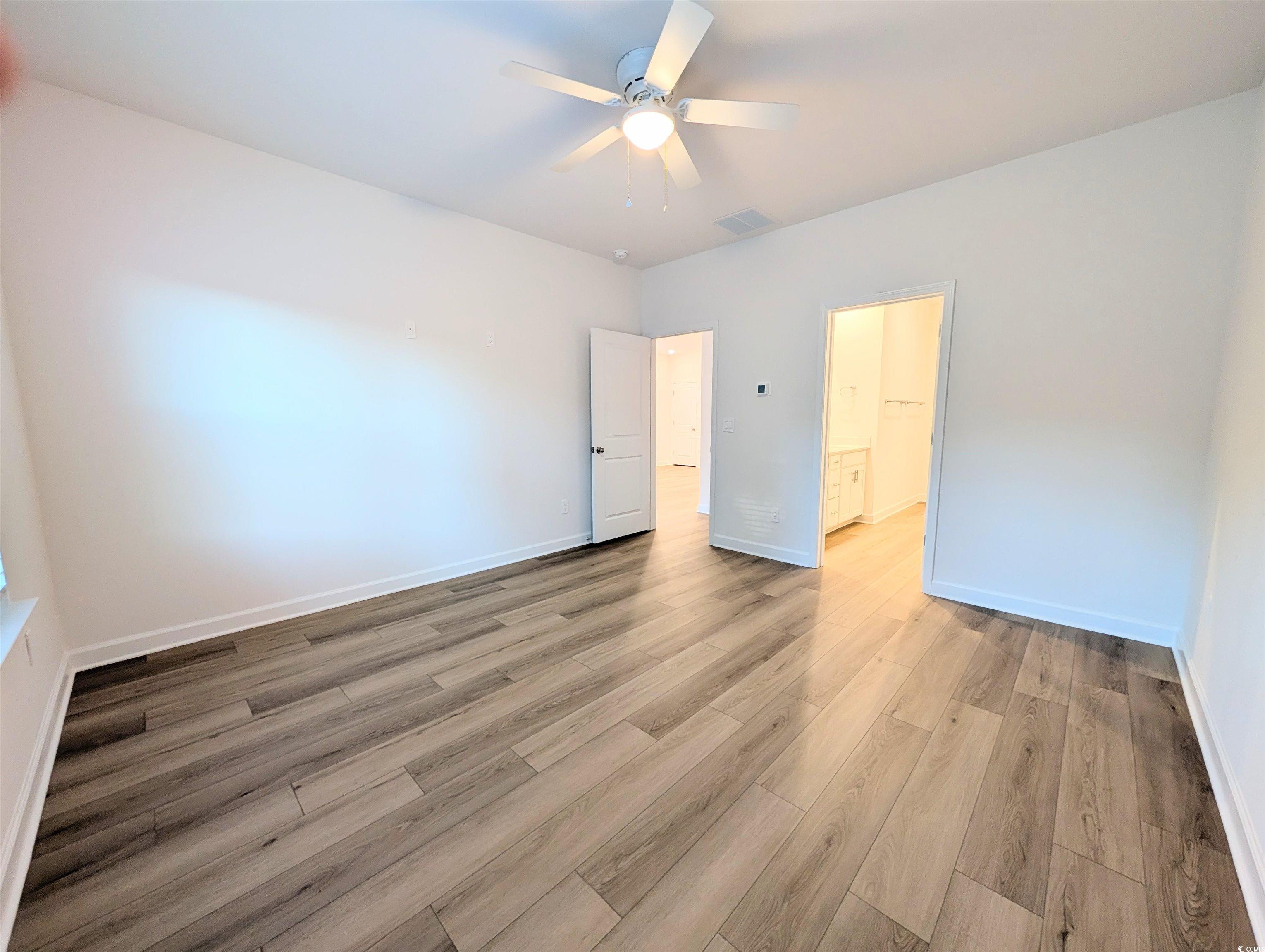 1109 Lauryn Oak Loop Longs, SC 29568 - Photo 16 of 40 Unfurnished bedroom featuring wood finished floors, a ceiling fan, and ensuite bathroom
