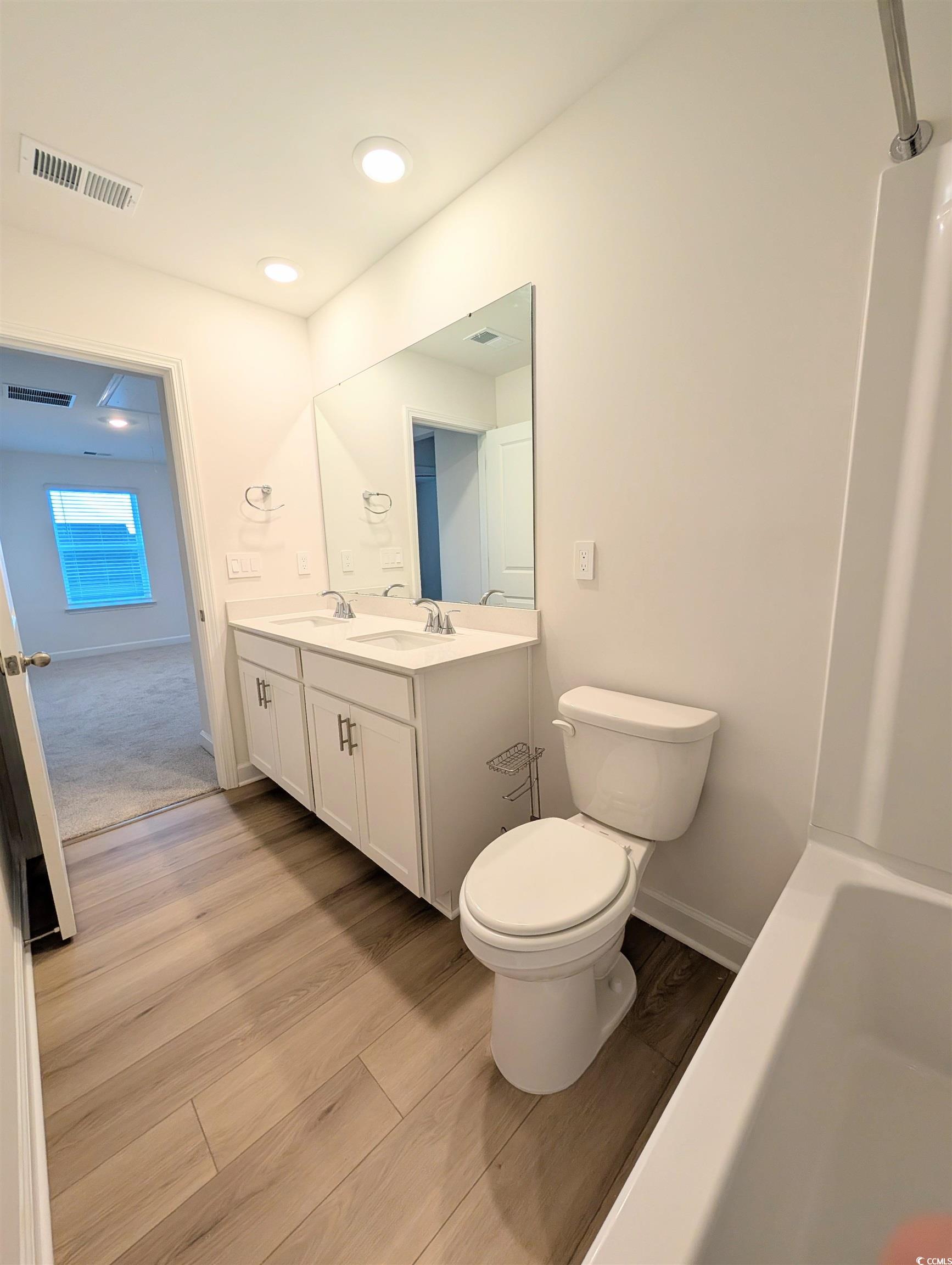 1109 Lauryn Oak Loop Longs, SC 29568 - Photo 26 of 40 Full bath with light wood finished floors, double vanity, shower combination, and recessed lighting