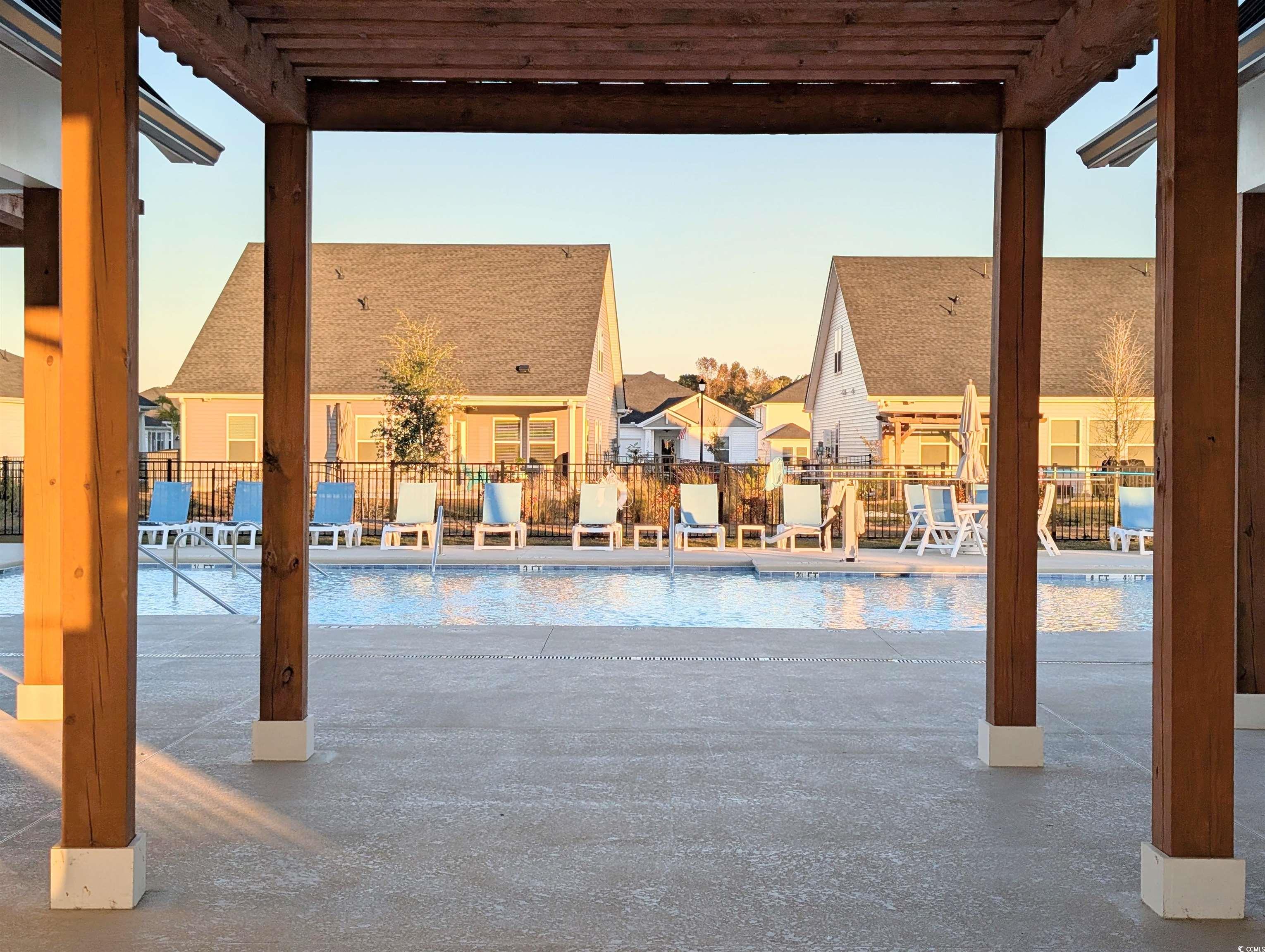 1109 Lauryn Oak Loop Longs, SC 29568 - Photo 37 of 40 Pool at dusk featuring a community pool, a patio area, and a pergola