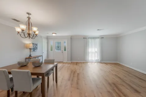a view of a dining room with furniture wooden floor and chandelier