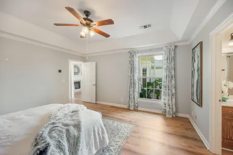 a bedroom with a large bed and a chandelier fan