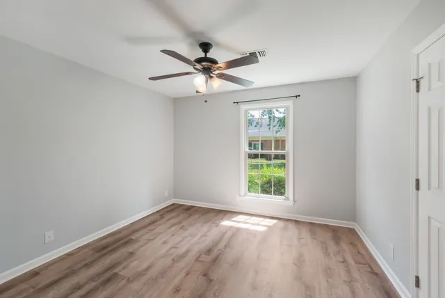 wooden floor in an empty room with a window