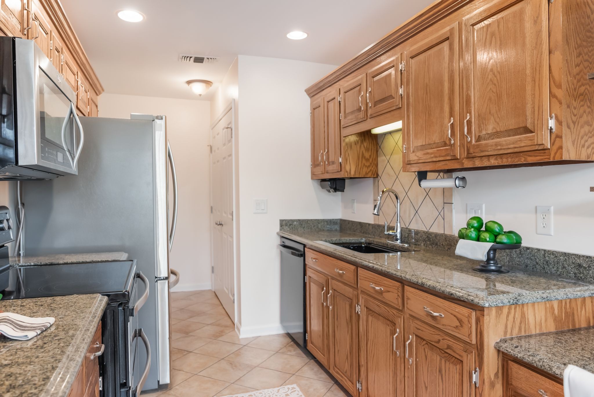 1281 General George Patton Road Nashville, TN 37221 - Photo 6 of 32 a kitchen with stainless steel appliances granite countertop a sink a stove and a wooden cabinets