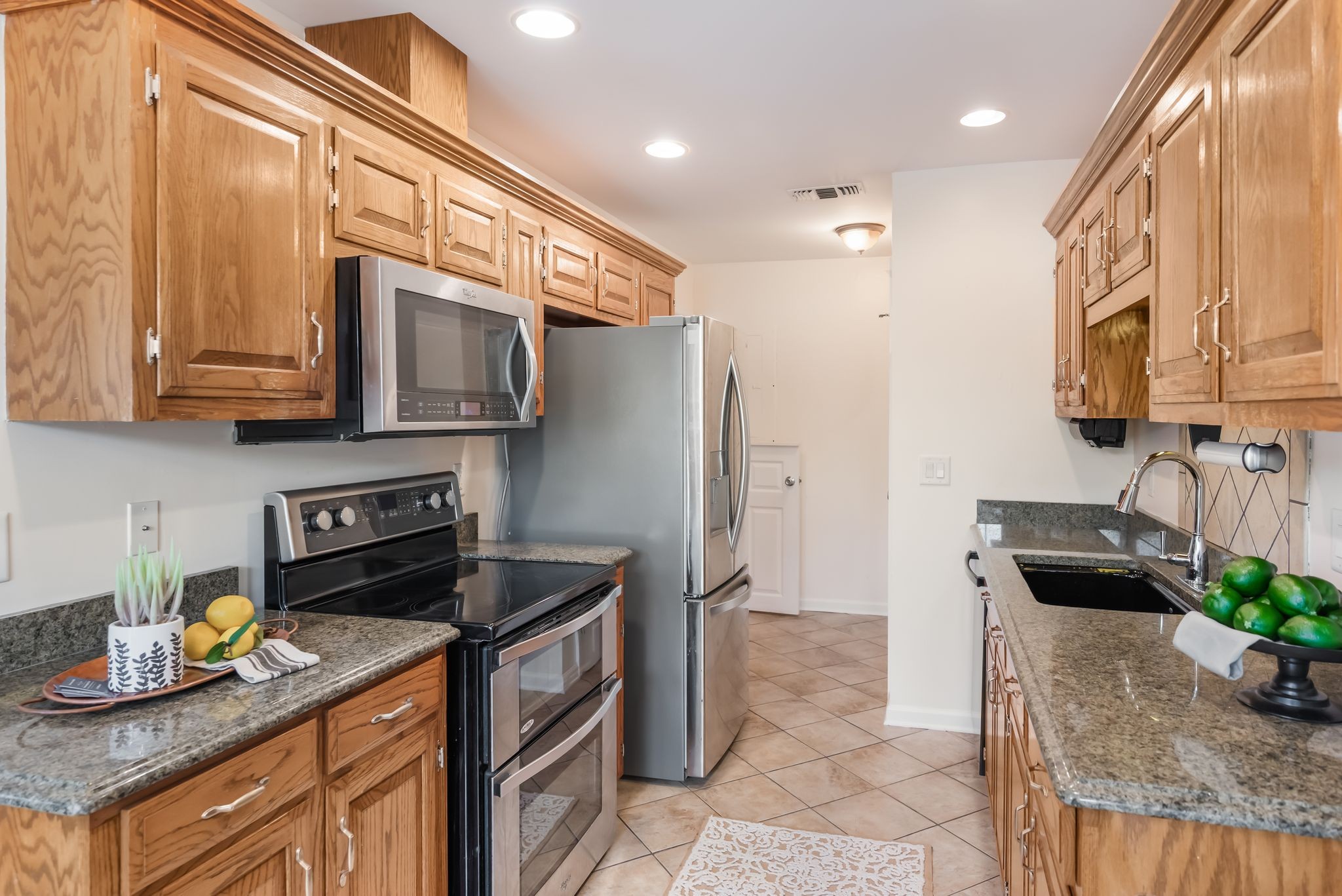 1281 General George Patton Road Nashville, TN 37221 - Photo 7 of 32 a kitchen with granite countertop a stove a sink and a refrigerator