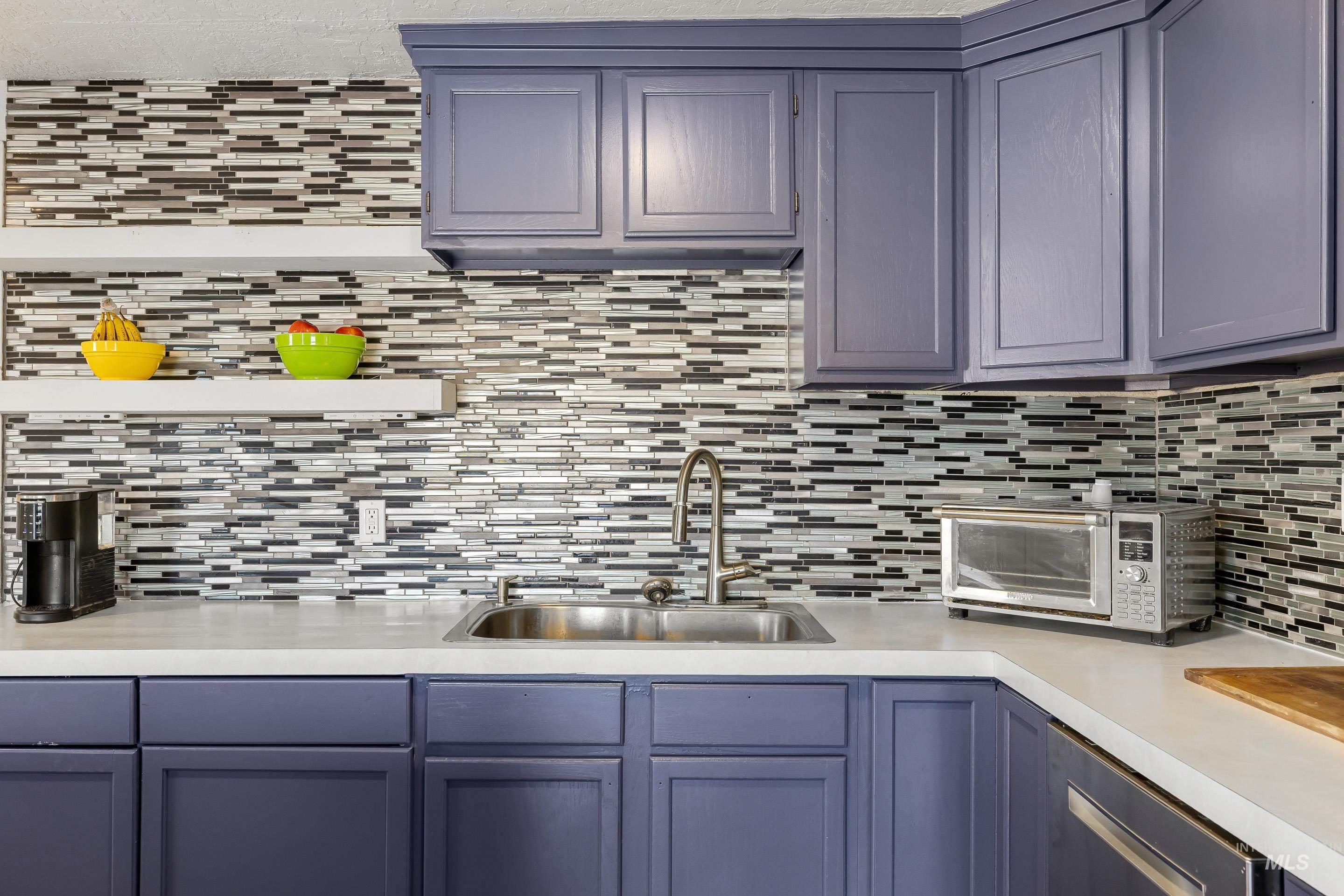 10294 West Fox Ridge Drive Boise, ID 83709 - Photo 11 of 50 Kitchen featuring light countertops, stainless steel dishwasher, decorative backsplash, and blue cabinets