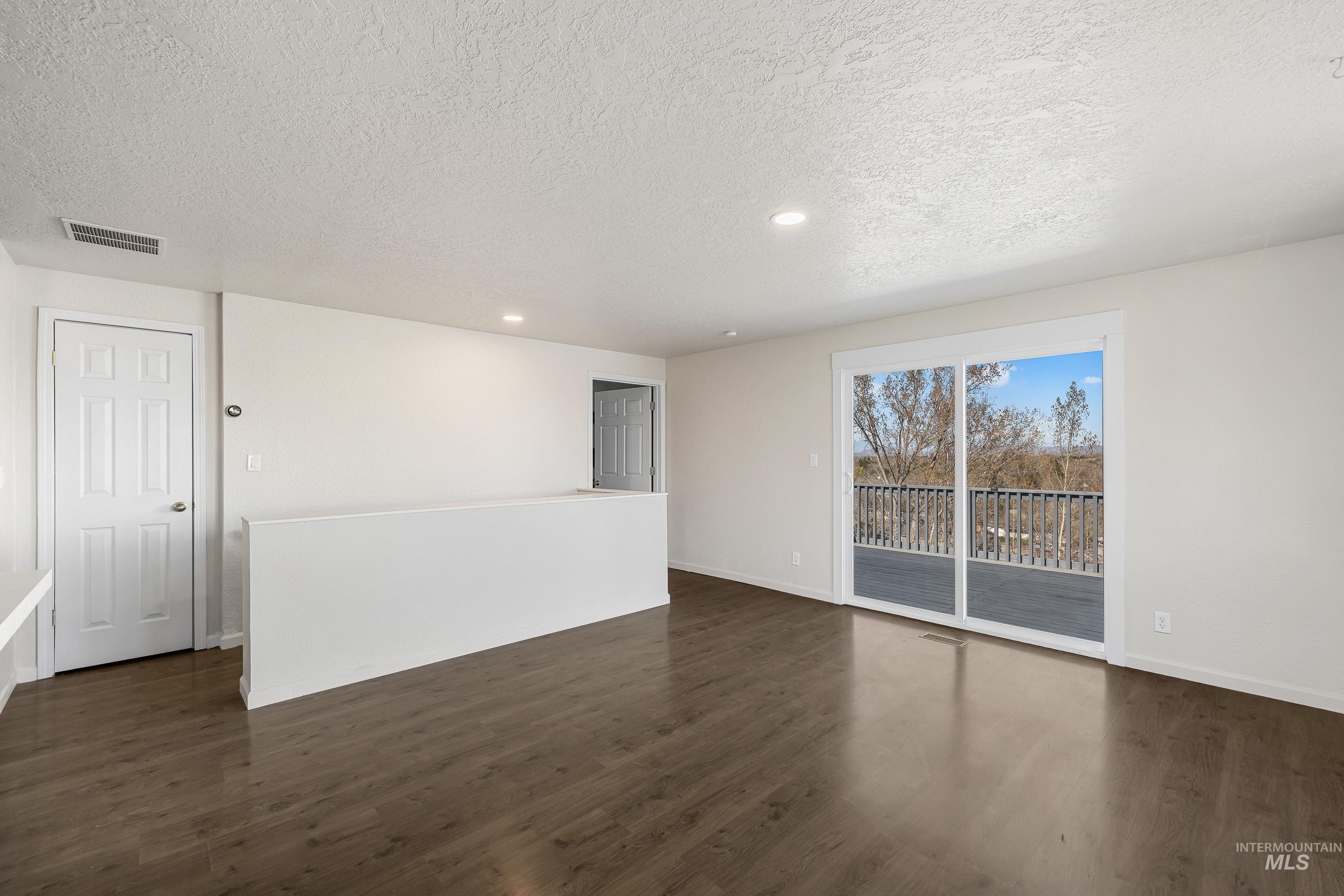 10294 West Fox Ridge Drive Boise, ID 83709 - Photo 13 of 50 Spare room featuring recessed lighting, dark wood-style floors, and a textured ceiling
