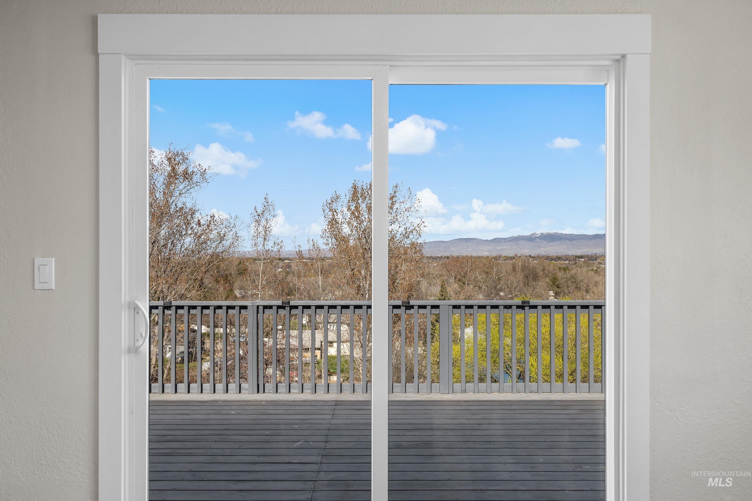 10294 West Fox Ridge Drive Boise, ID 83709 - Photo 15 of 50 Doorway to outside featuring a textured wall, a mountain view, and healthy amount of natural light