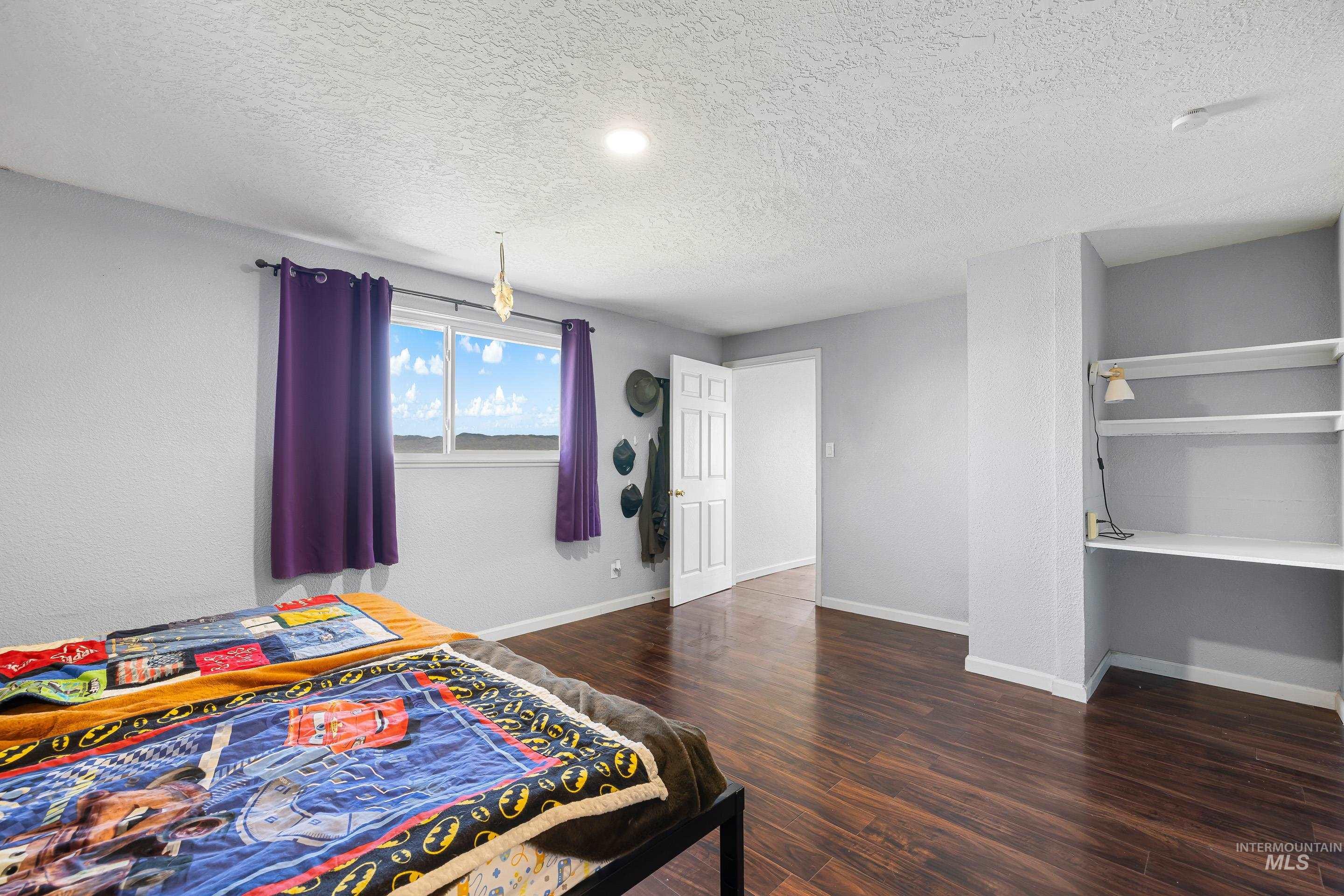 10294 West Fox Ridge Drive Boise, ID 83709 - Photo 17 of 50 Bedroom featuring dark wood-type flooring and a textured ceiling