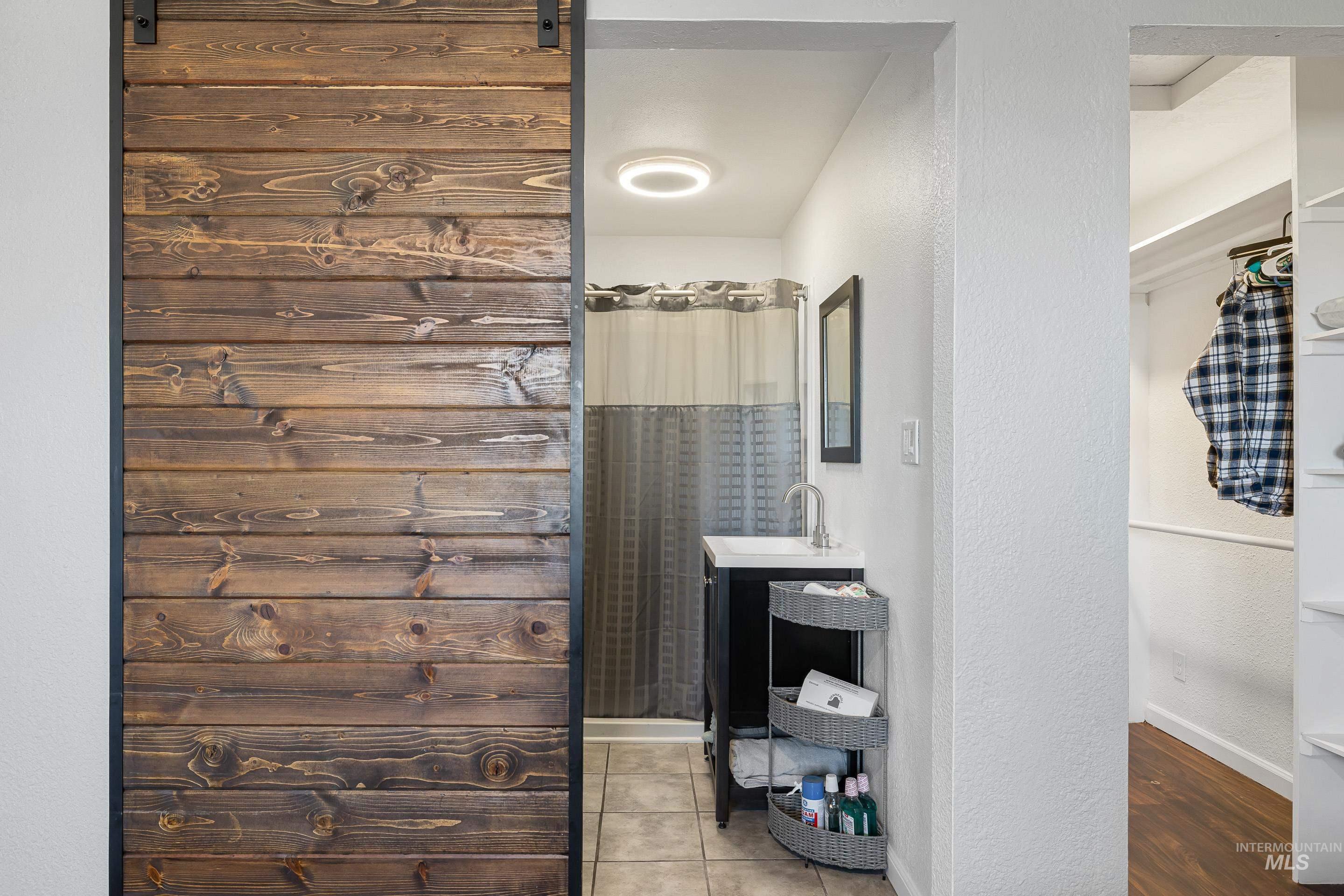 10294 West Fox Ridge Drive Boise, ID 83709 - Photo 20 of 50 Bathroom with a textured wall, a shower with curtain, vanity, and light tile patterned floors