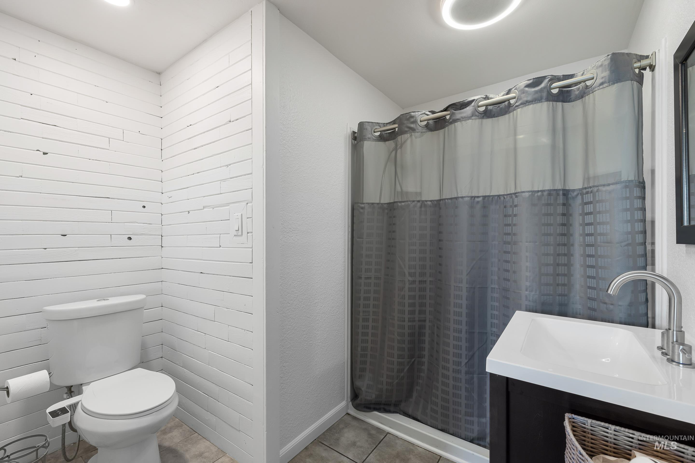 10294 West Fox Ridge Drive Boise, ID 83709 - Photo 21 of 50 Full bathroom with a shower stall, vanity, light tile patterned flooring, and a textured wall