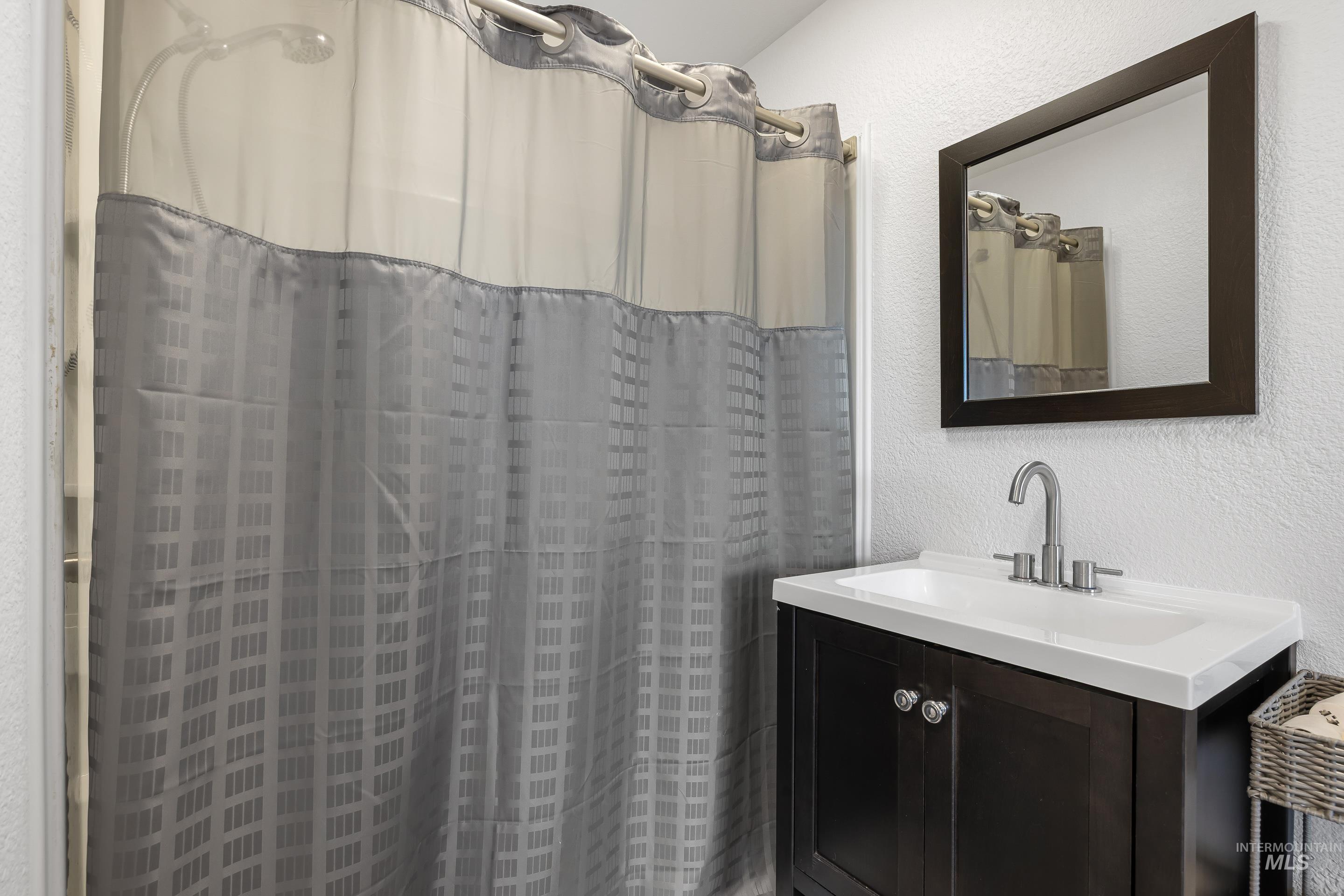 10294 West Fox Ridge Drive Boise, ID 83709 - Photo 23 of 50 Bathroom with a textured wall, vanity, and a shower with curtain