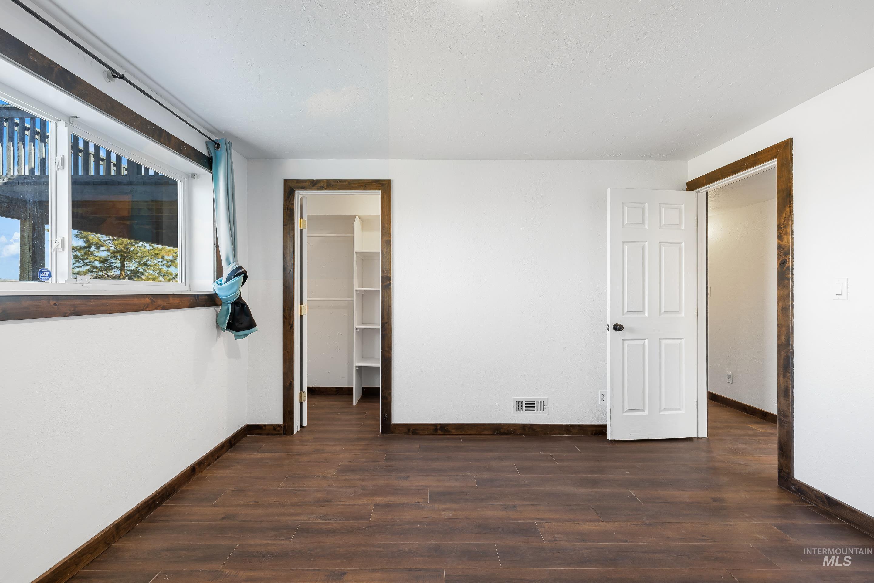 10294 West Fox Ridge Drive Boise, ID 83709 - Photo 28 of 50 Unfurnished bedroom featuring a walk in closet and dark wood-type flooring