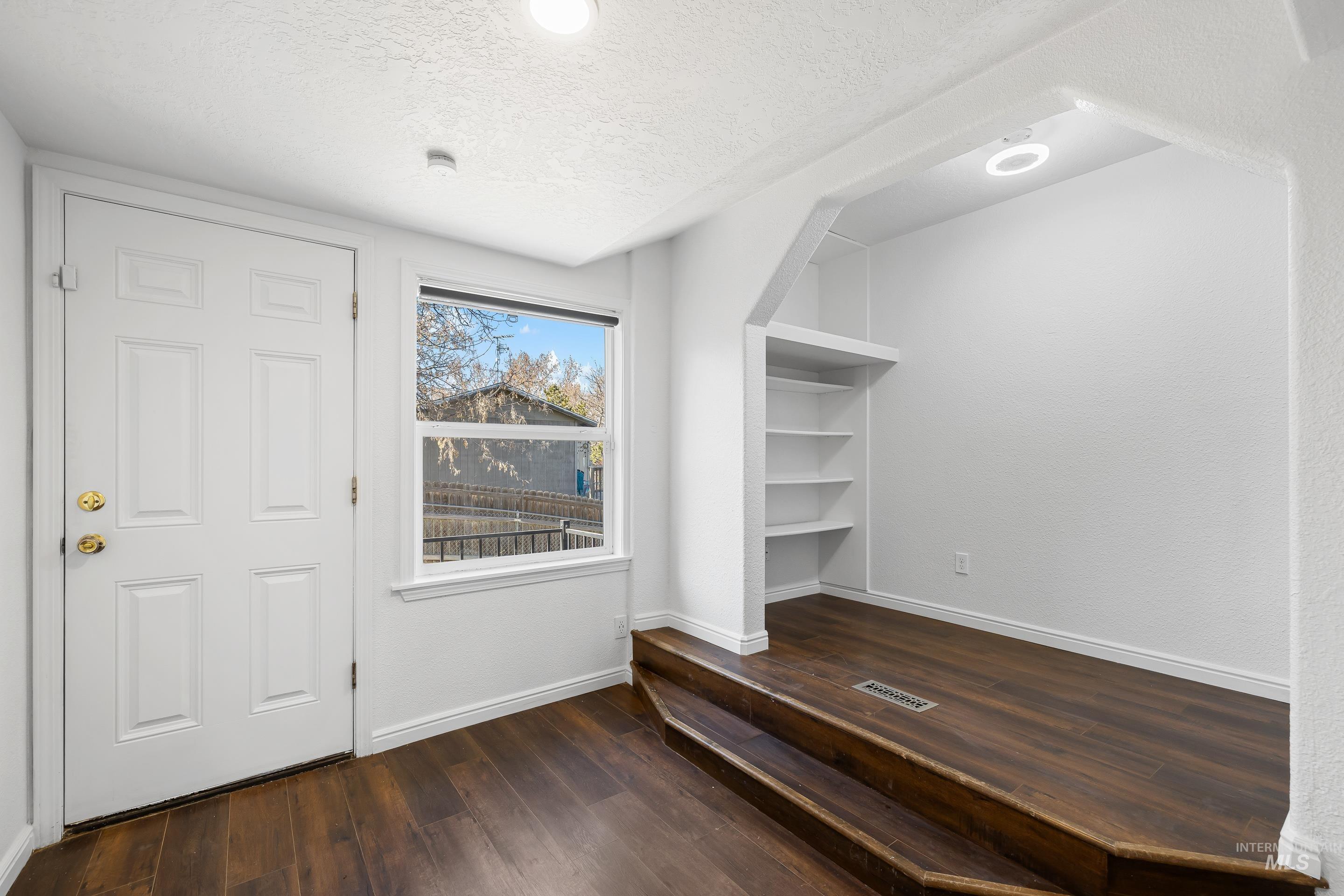 10294 West Fox Ridge Drive Boise, ID 83709 - Photo 33 of 50 Foyer entrance featuring dark wood-style floors and a textured ceiling