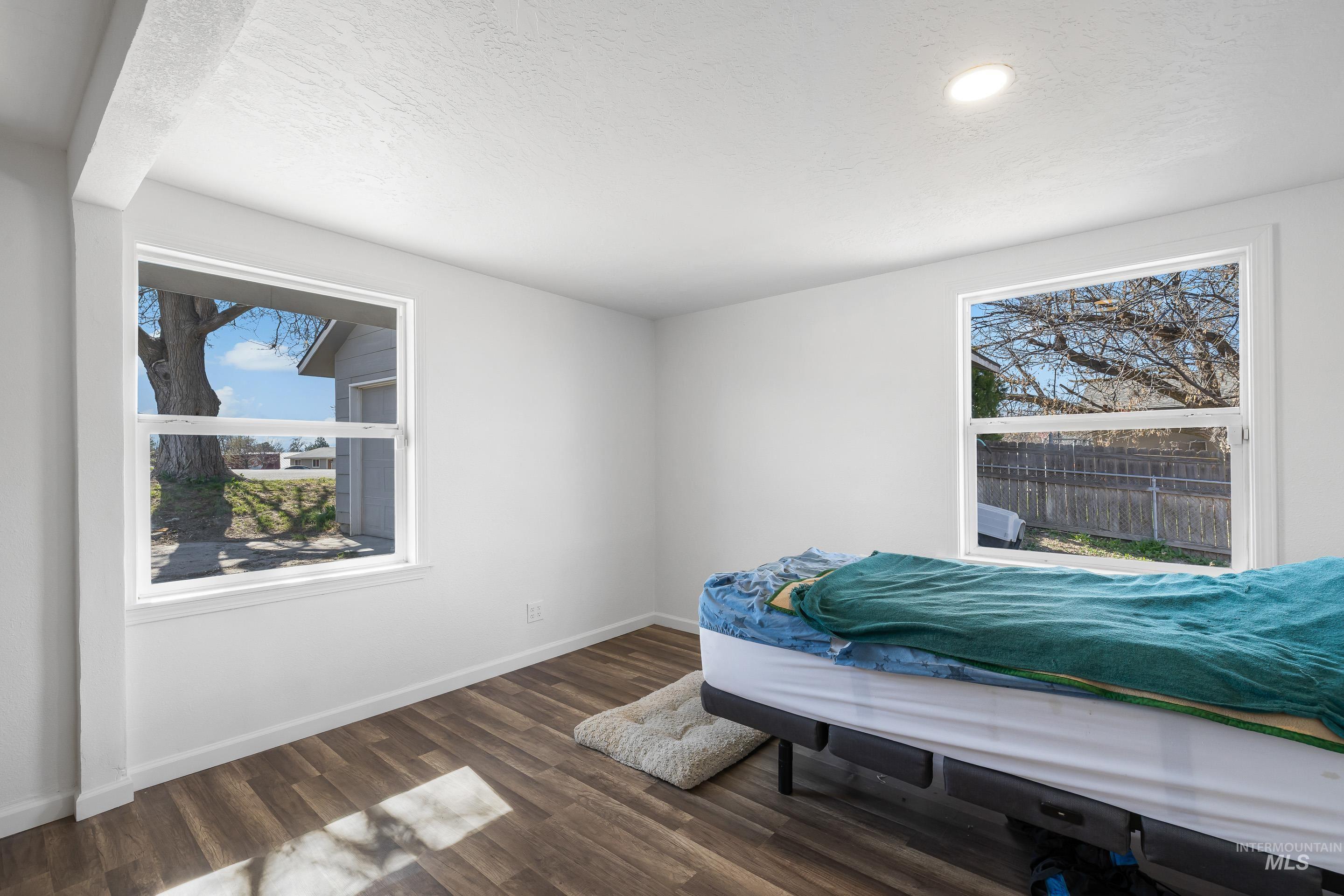 10294 West Fox Ridge Drive Boise, ID 83709 - Photo 35 of 50 Bedroom featuring dark wood-style flooring, multiple windows, and a textured ceiling